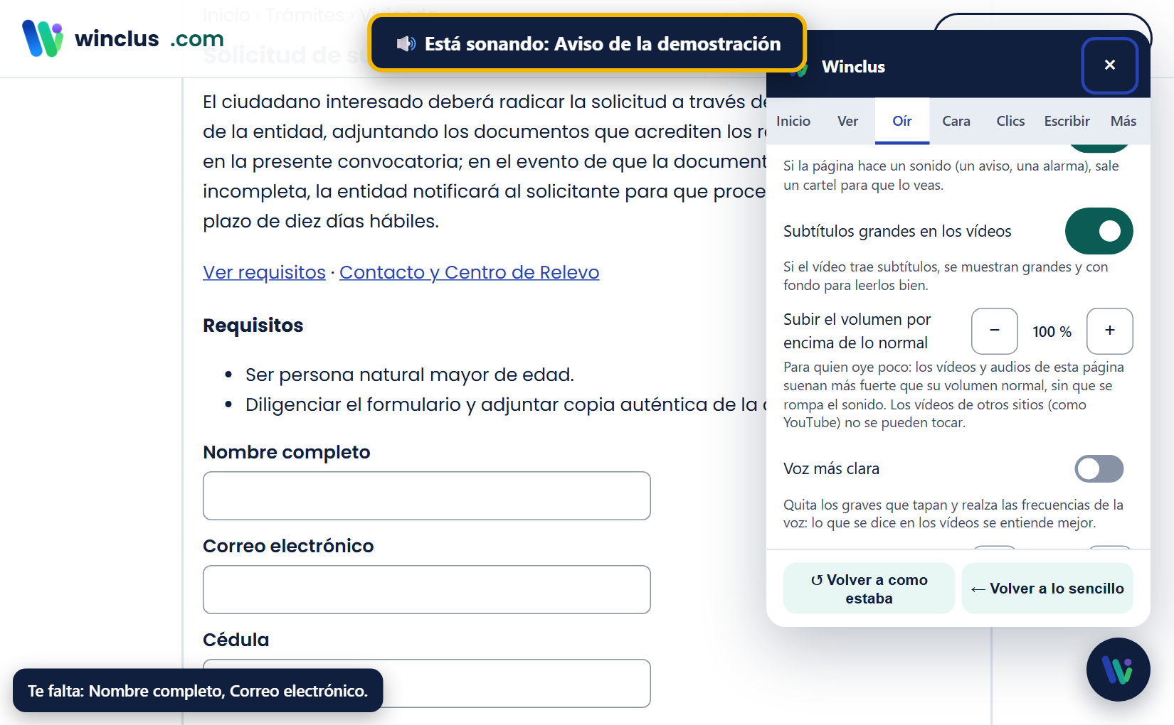Arriba, el aviso «Está sonando: Aviso de la demostración»; en el panel, pestaña Oír, «Avisar en pantalla cuando algo suena» y «Subtítulos grandes» activados, y los botones de subtítulos en vivo y transcripción.